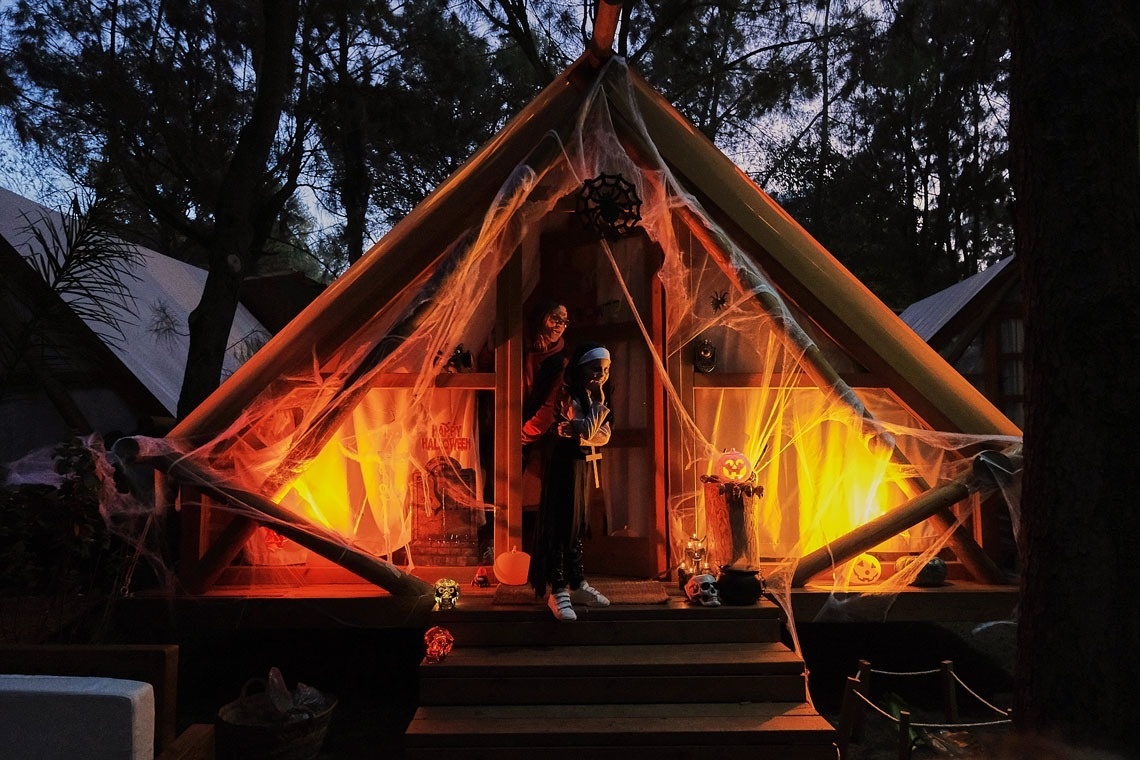 a person standing in front of a tent decorated for halloween