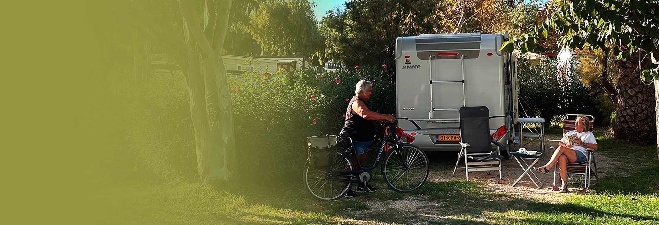 un hombre y una mujer están sentados en sillas frente a una caravana