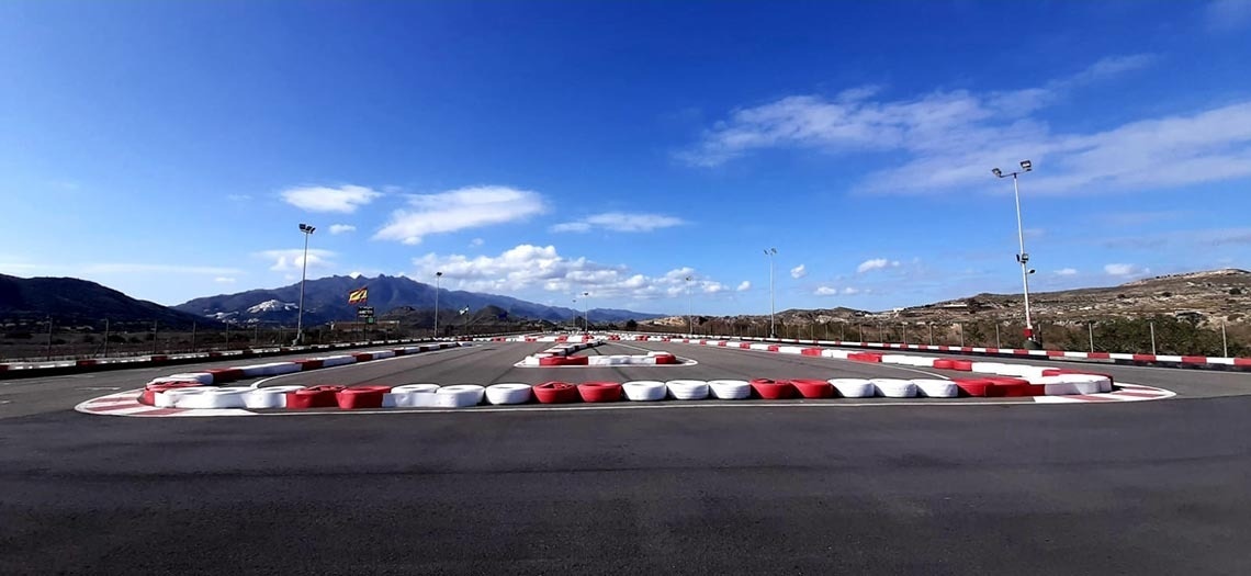 an empty go kart track with mountains in the background