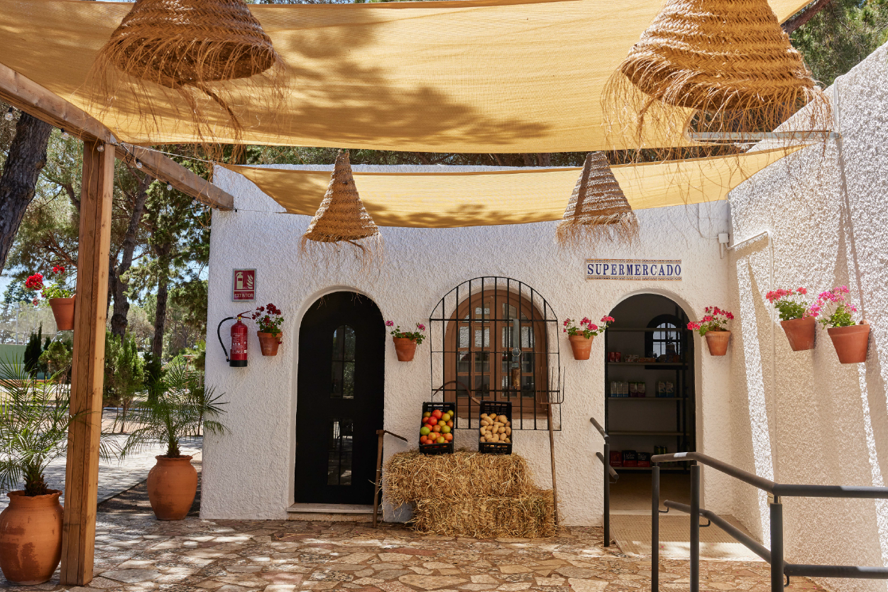 een witte gebouw met een bordje supermarkado bovenop