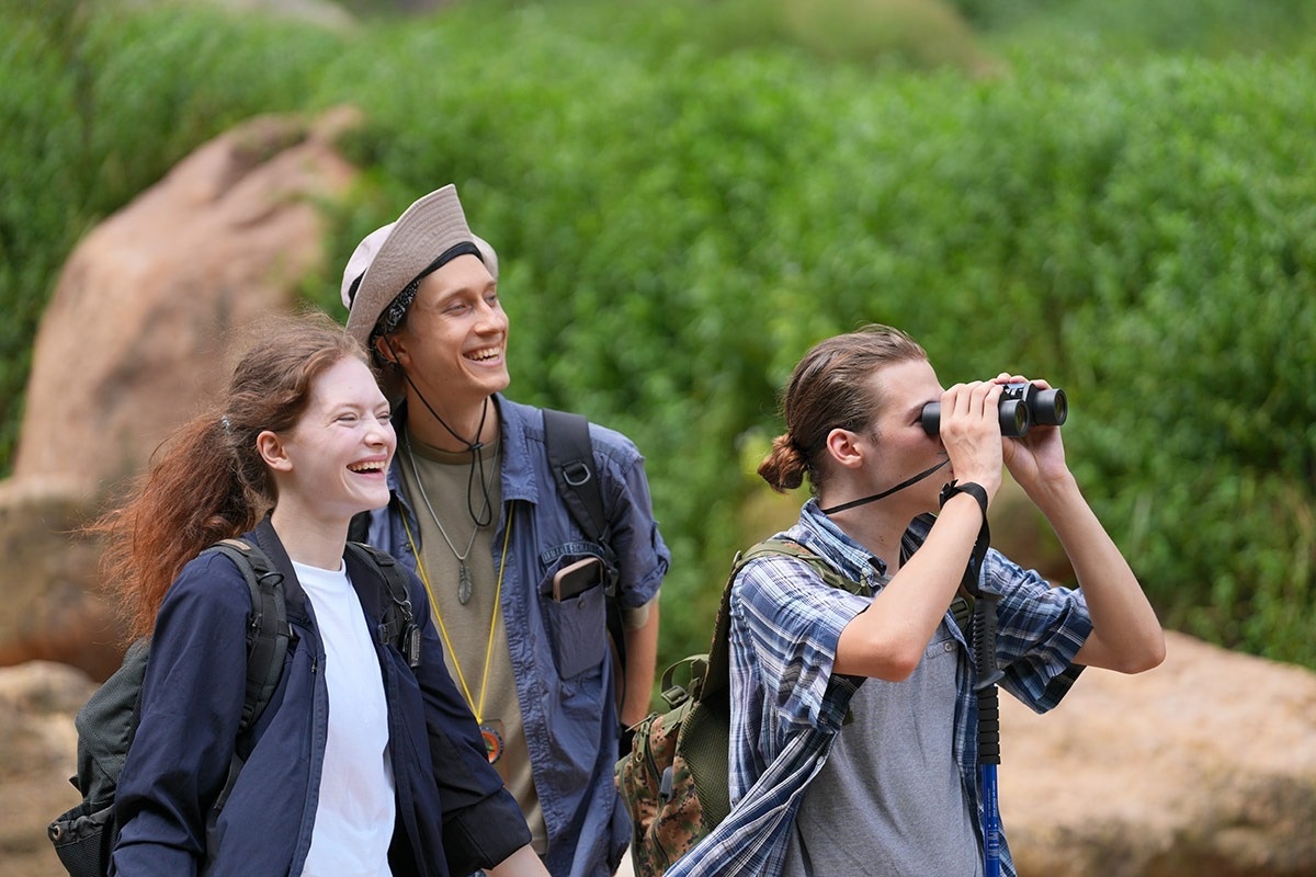 ein Mann schaut durch ein Fernglas , während eine Frau lacht