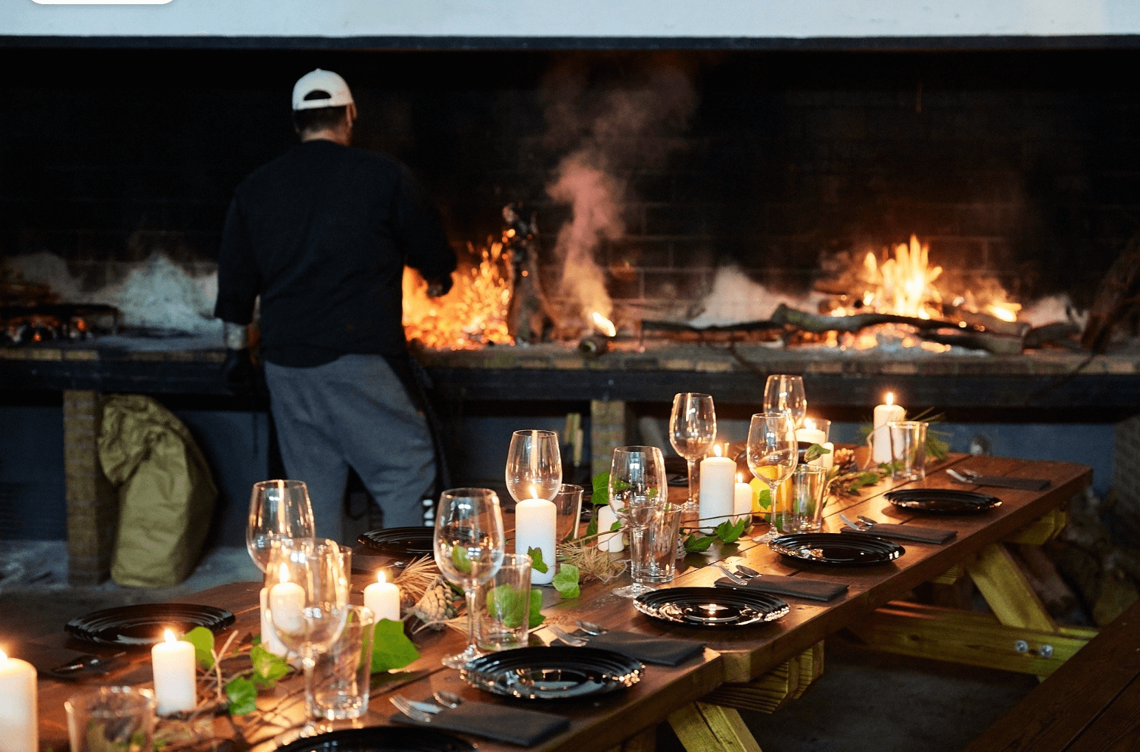 a group of people standing around picnic tables under a roof