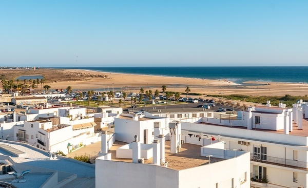 a row of white buildings with a beach in the background