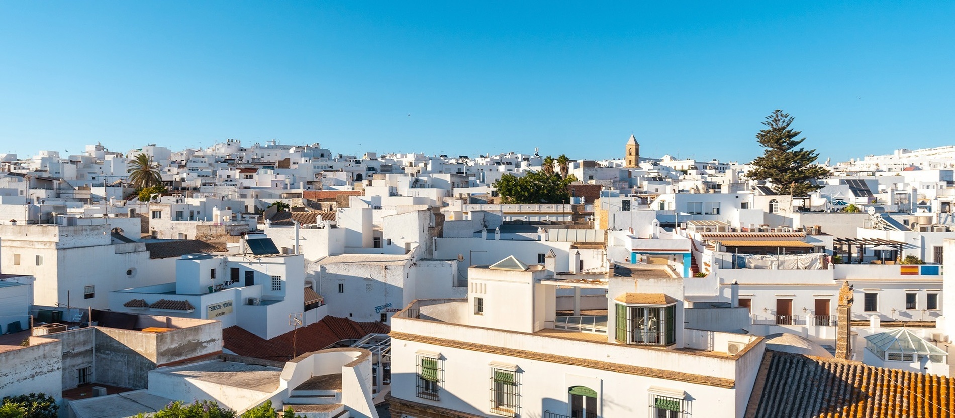 un grupo de edificios blancos con una torre en el fondo