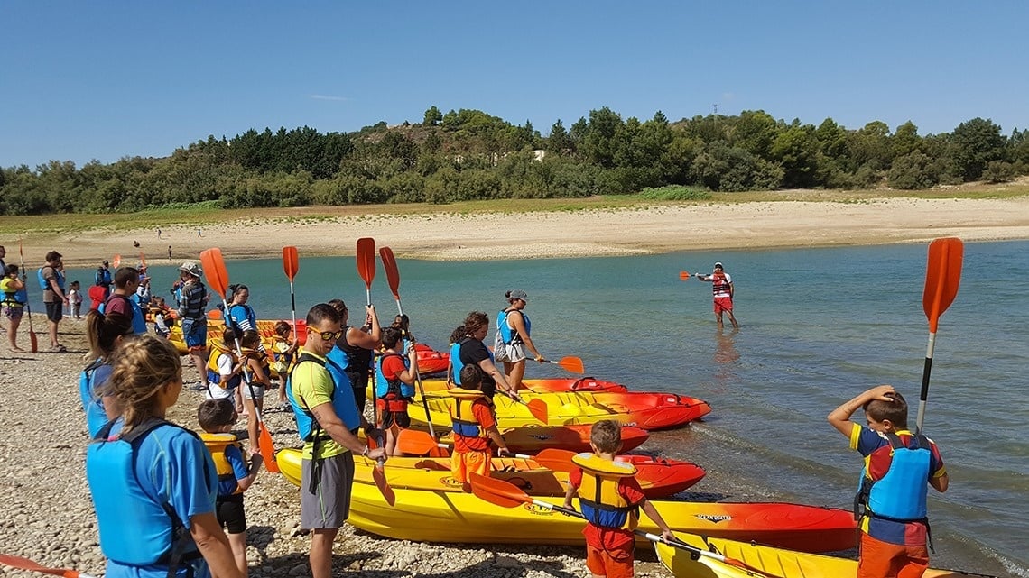 un grup de persones en kayaks a la orilla d' un riu