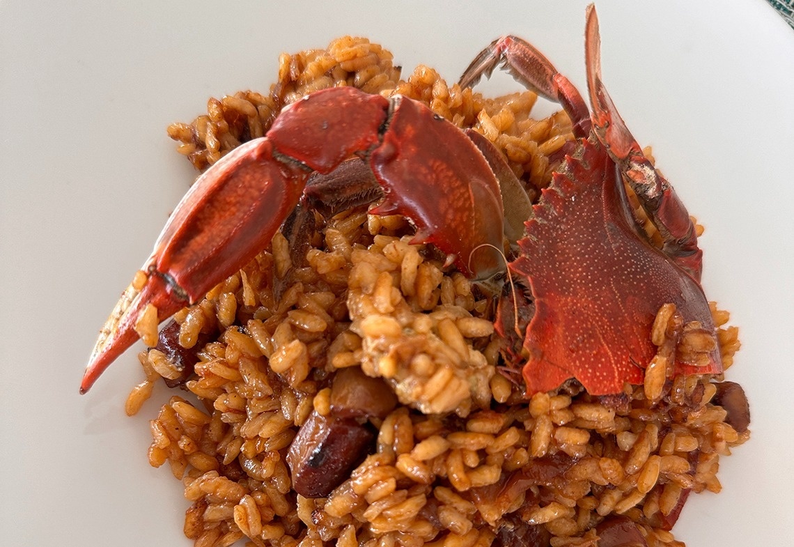 a plate of rice with a crab on top of it