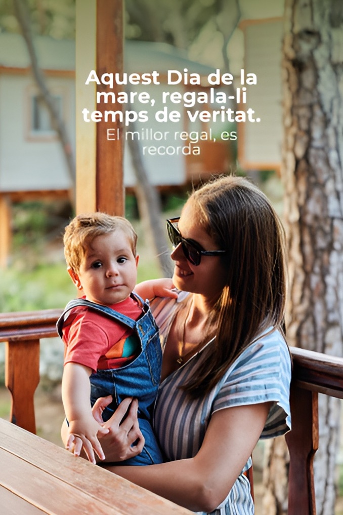Un hombre sonriente interactúa felizmente con un niño pequeño sostenido sobre una mesa de madera al aire libre, bajo el mensaje "Setmana Santa en TAIGÀ" que promociona unas vacaciones familiares.