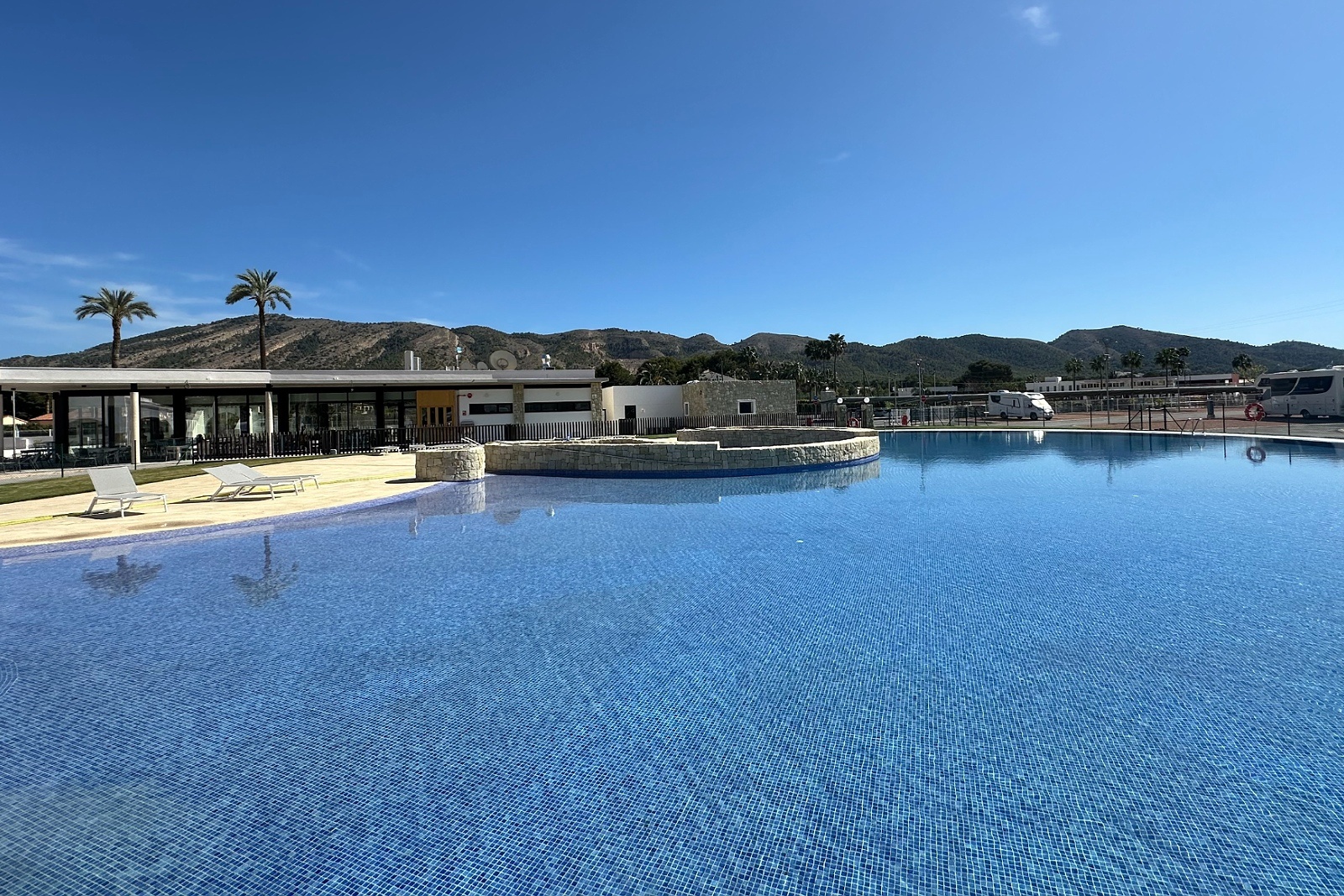 Großer Poolbereich im Taiga: Corporativa Hotel mit Liegestühlen und Bergblick.