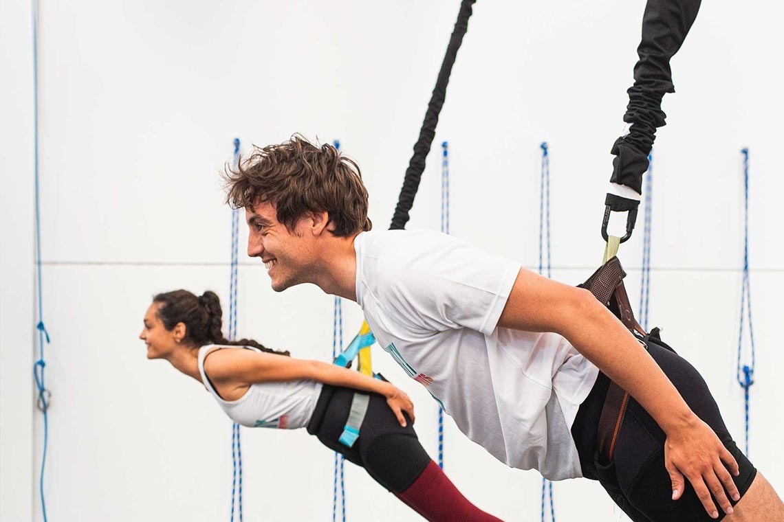 a man and a woman are doing exercises on a bungee cord