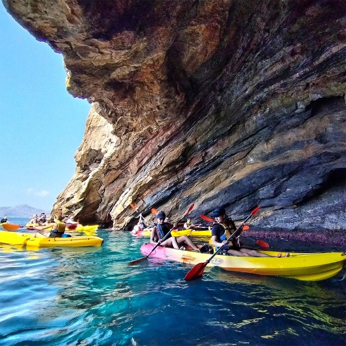 un grupo de personas en kayaks amarillos en el océano