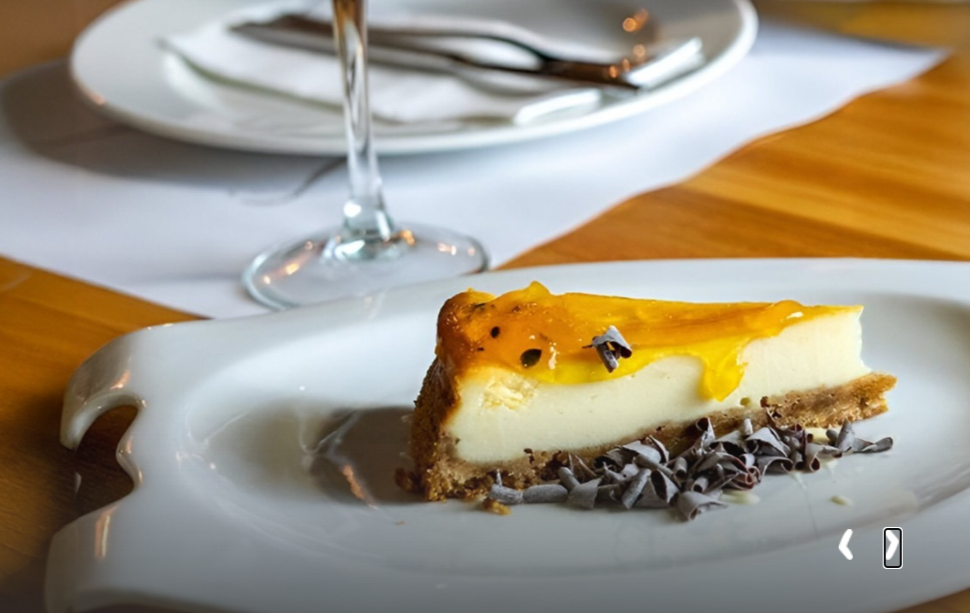 Tarta deTaiga: Corporativa en plato blanco, con baño de fruta y virutas de chocolate.