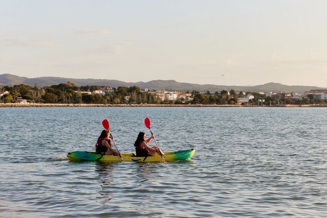a man and a woman are paddling kayaks on a lake