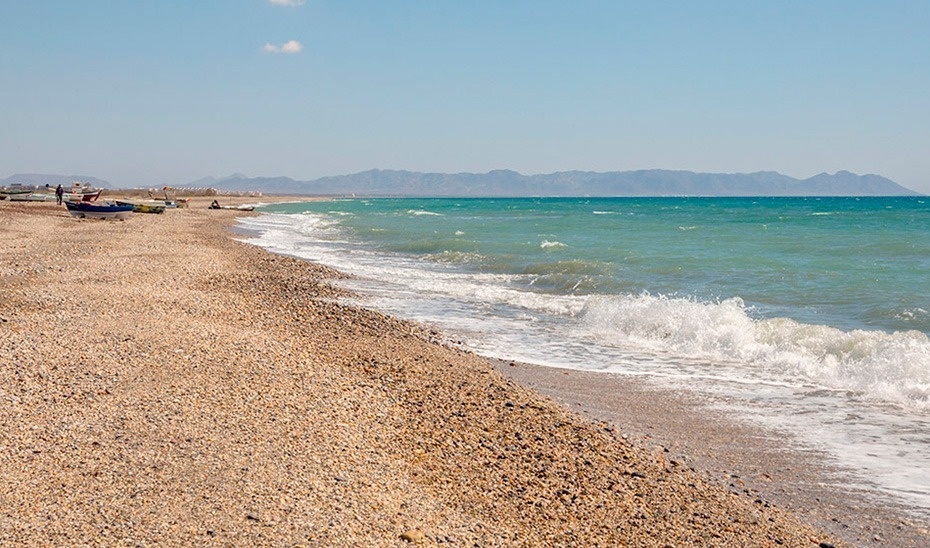 una platja de sable amb alguns barcos a l' aigua