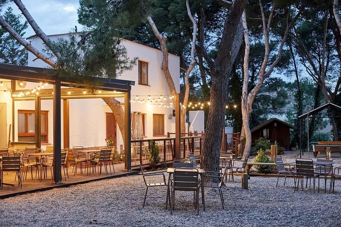 un grupo de personas se reúnen en un cobertizo con mesas de picnic