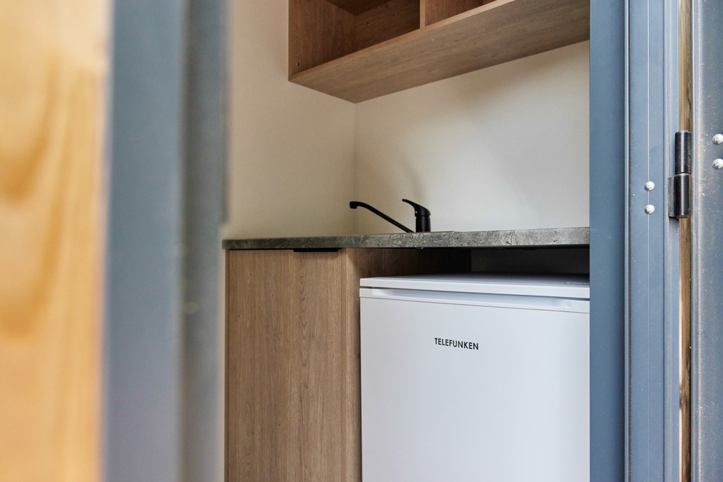 un pequeño refrigerador telefunken está en una cocina