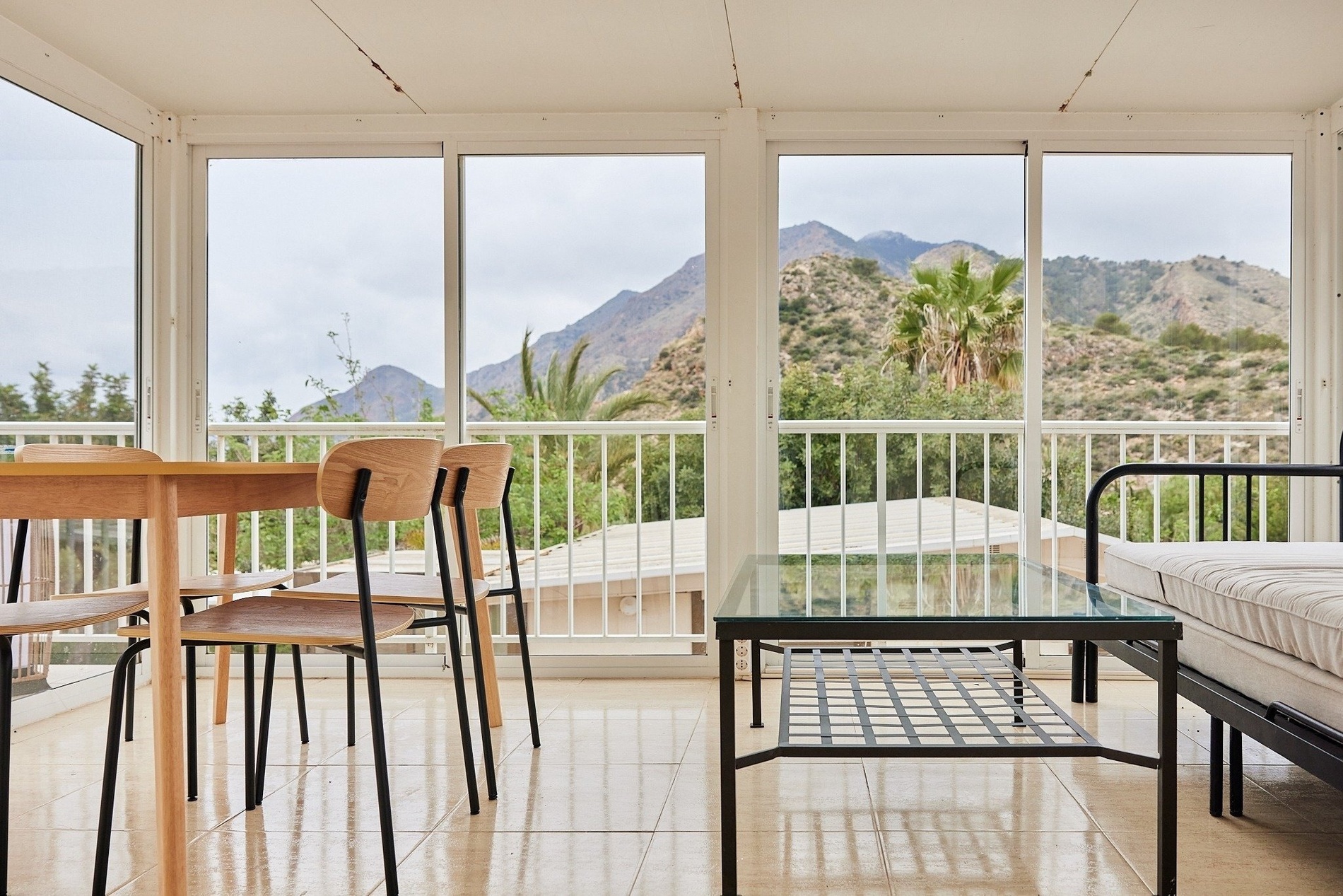 a living room with a table and chairs and a view of mountains