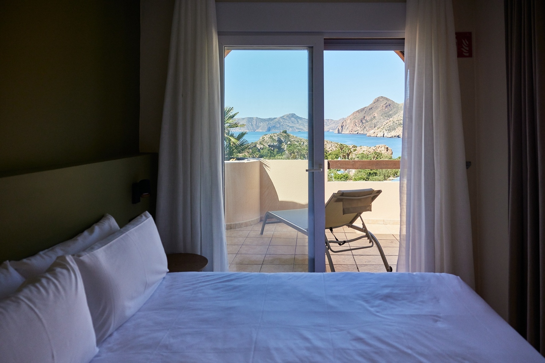 a hotel room with a view of the ocean and mountains