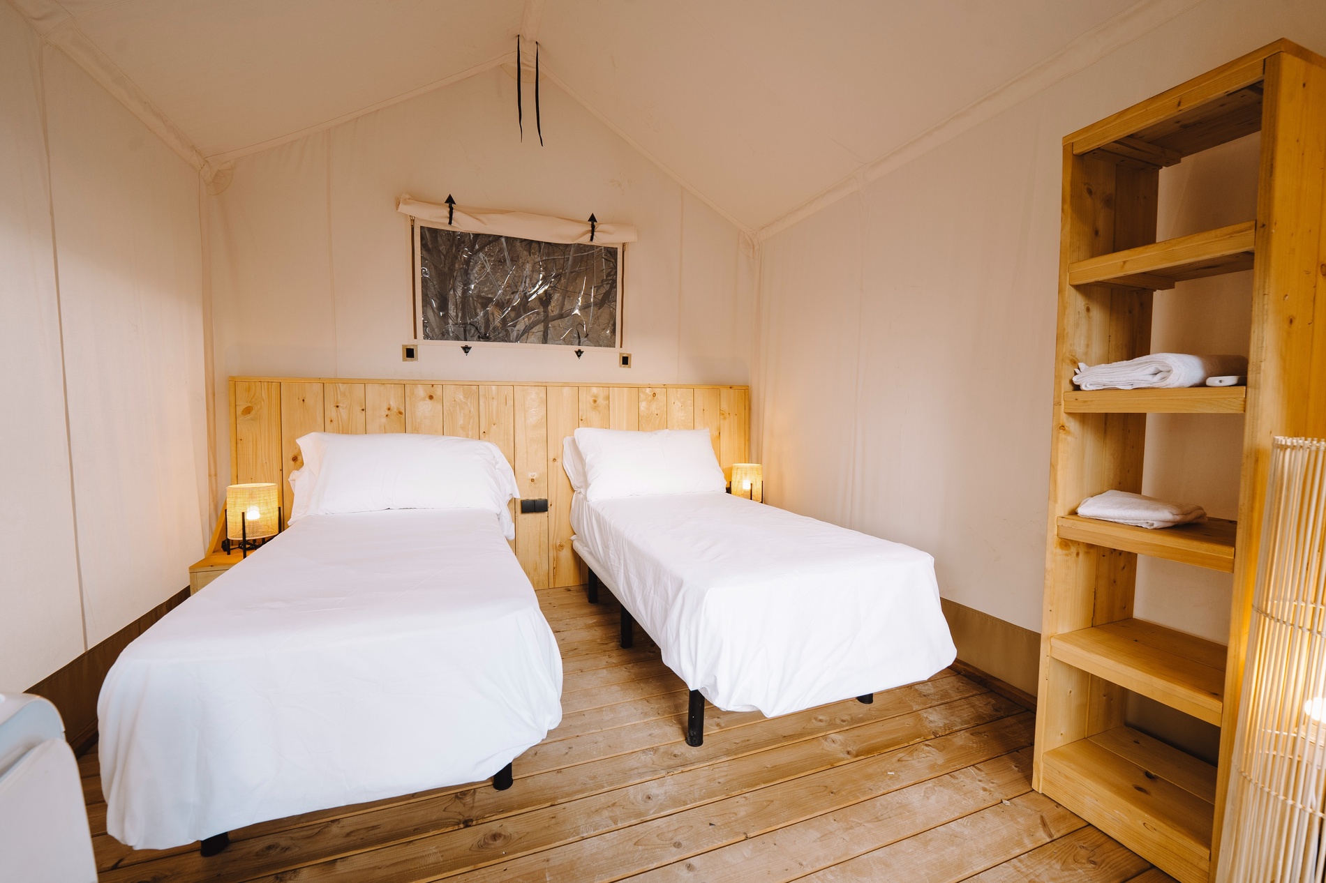 ein Schlafzimmer mit zwei Betten und einem Holzregal