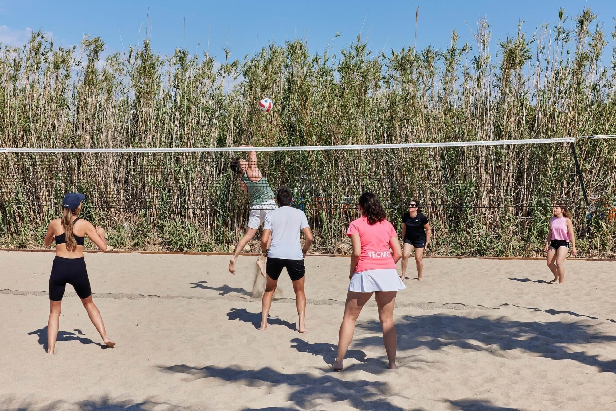 un grup de persones jugant a voleibol de platja
