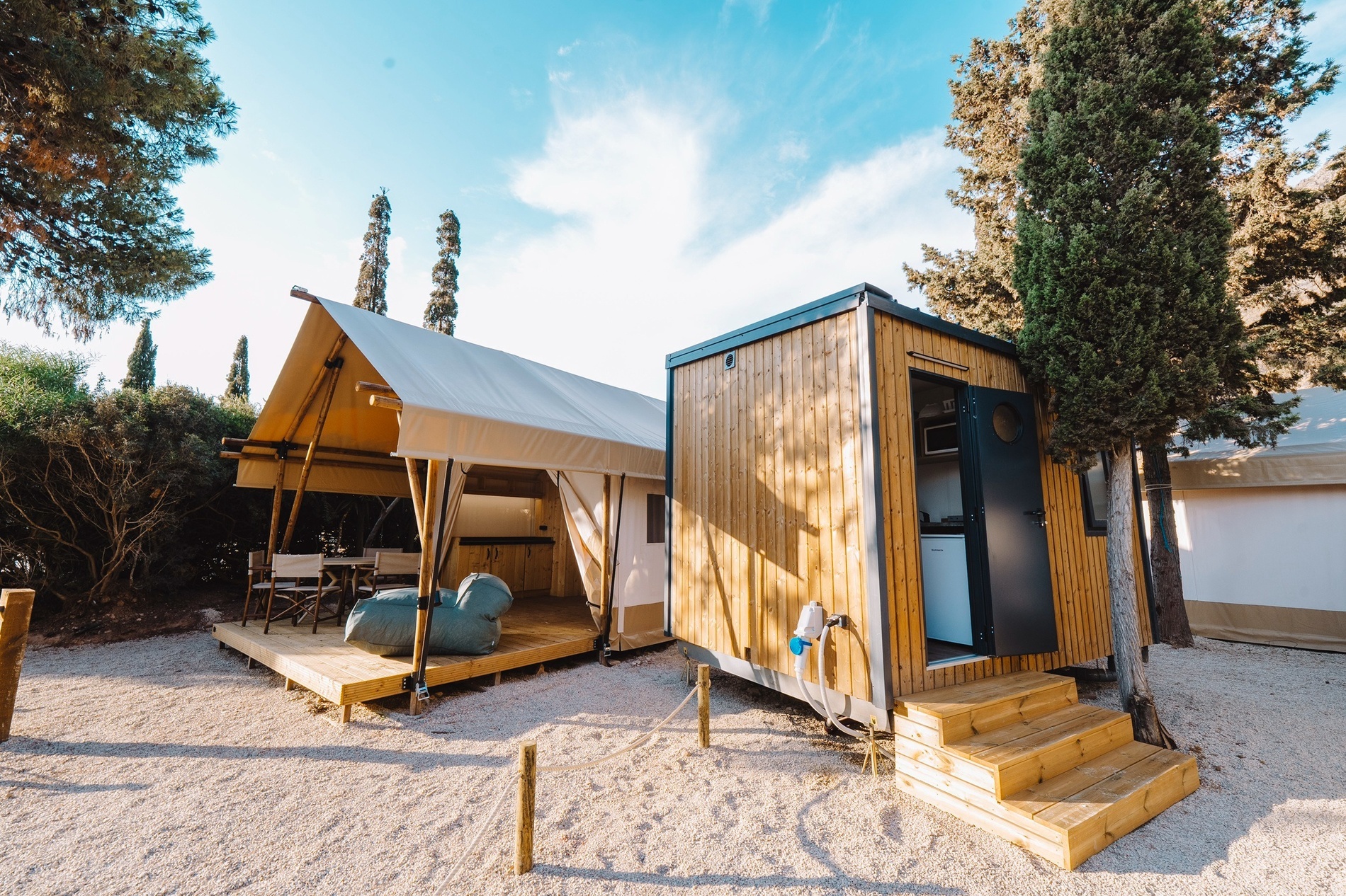 ein kleines Holzhaus neben einem großen Zelt