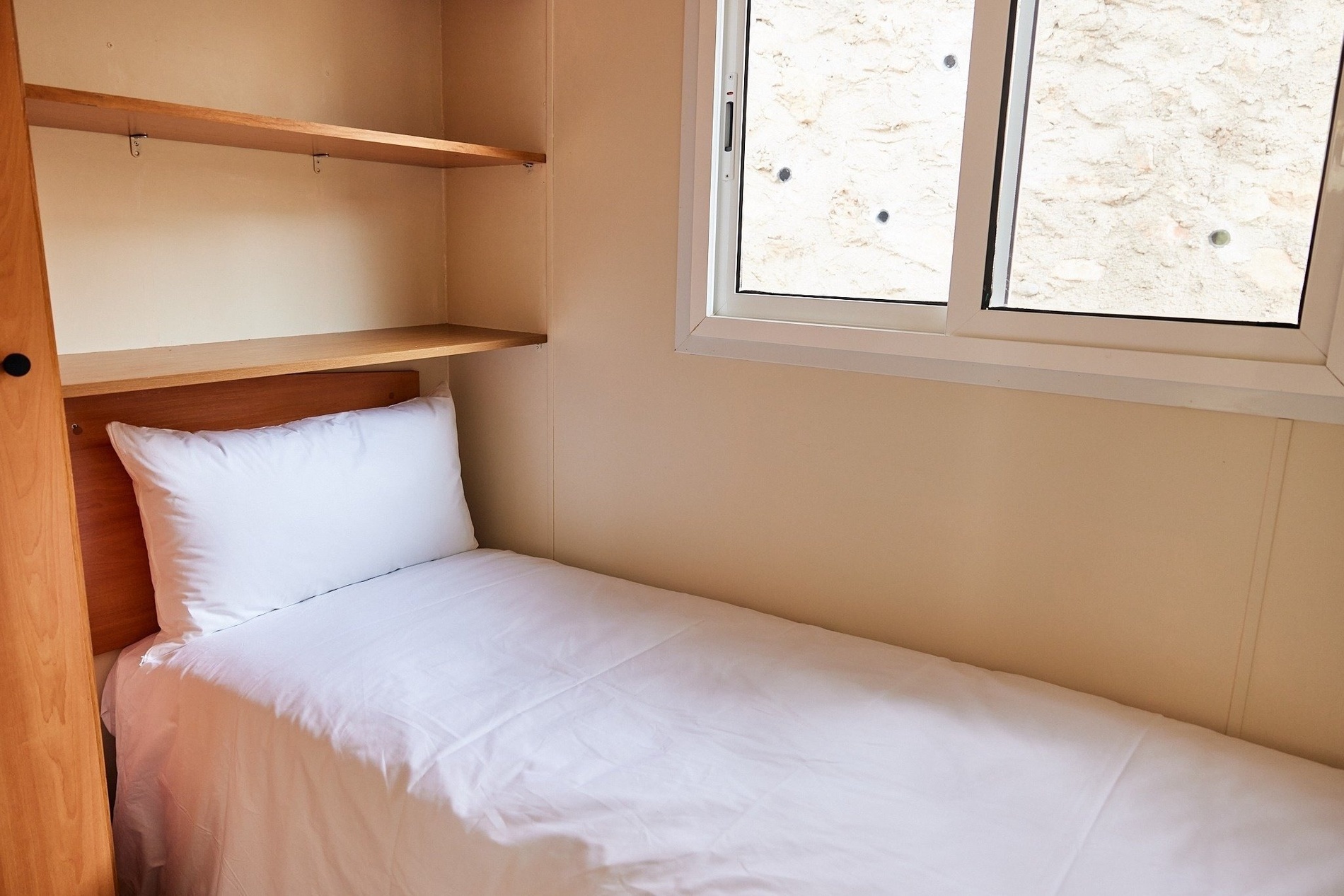 a small bedroom with a single bed and a window