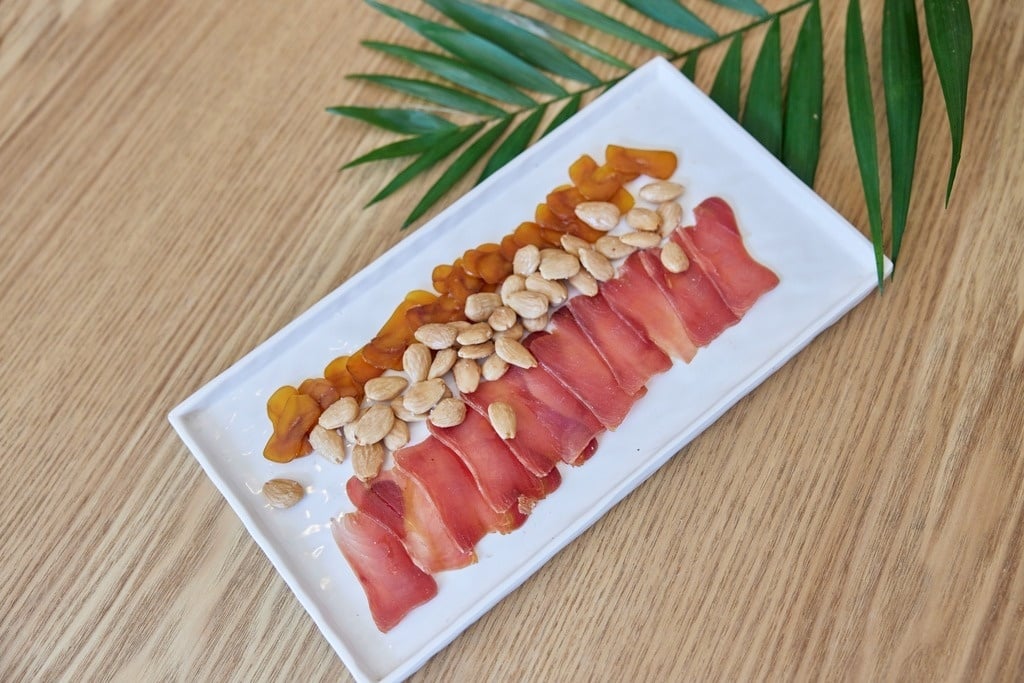 a group of people sit at tables outside a building with a sign that says bar