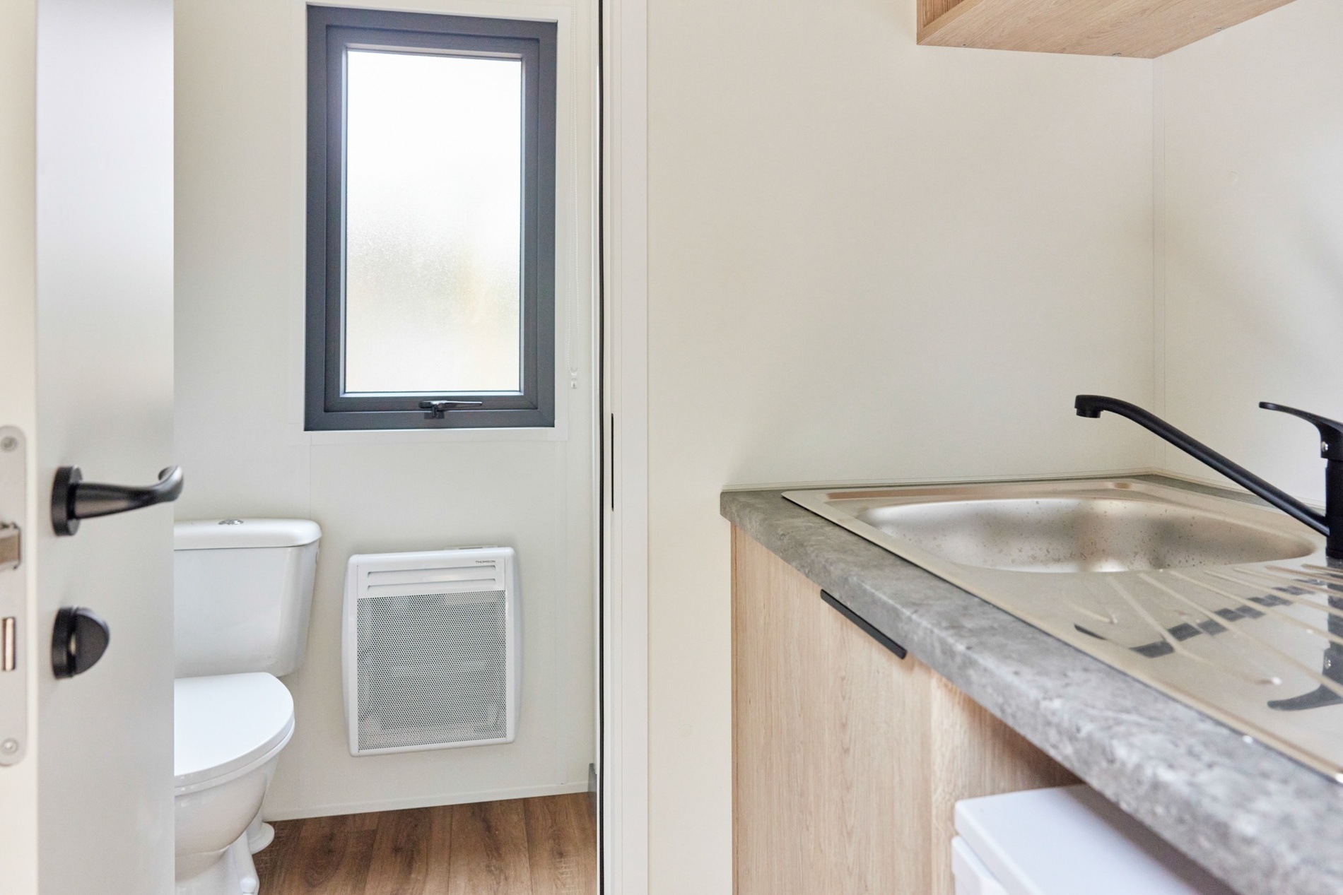 ein Badezimmer mit Toilette , Spüle und Fenster