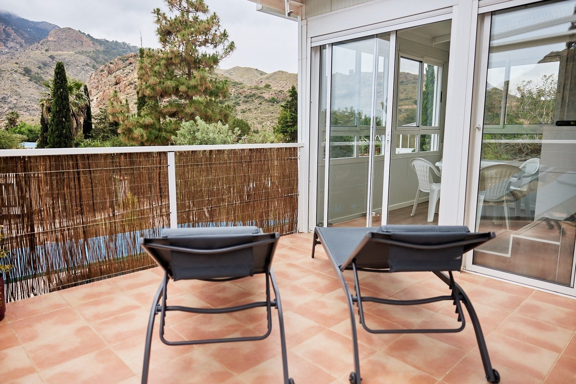 two chairs on a balcony with a mountain in the background
