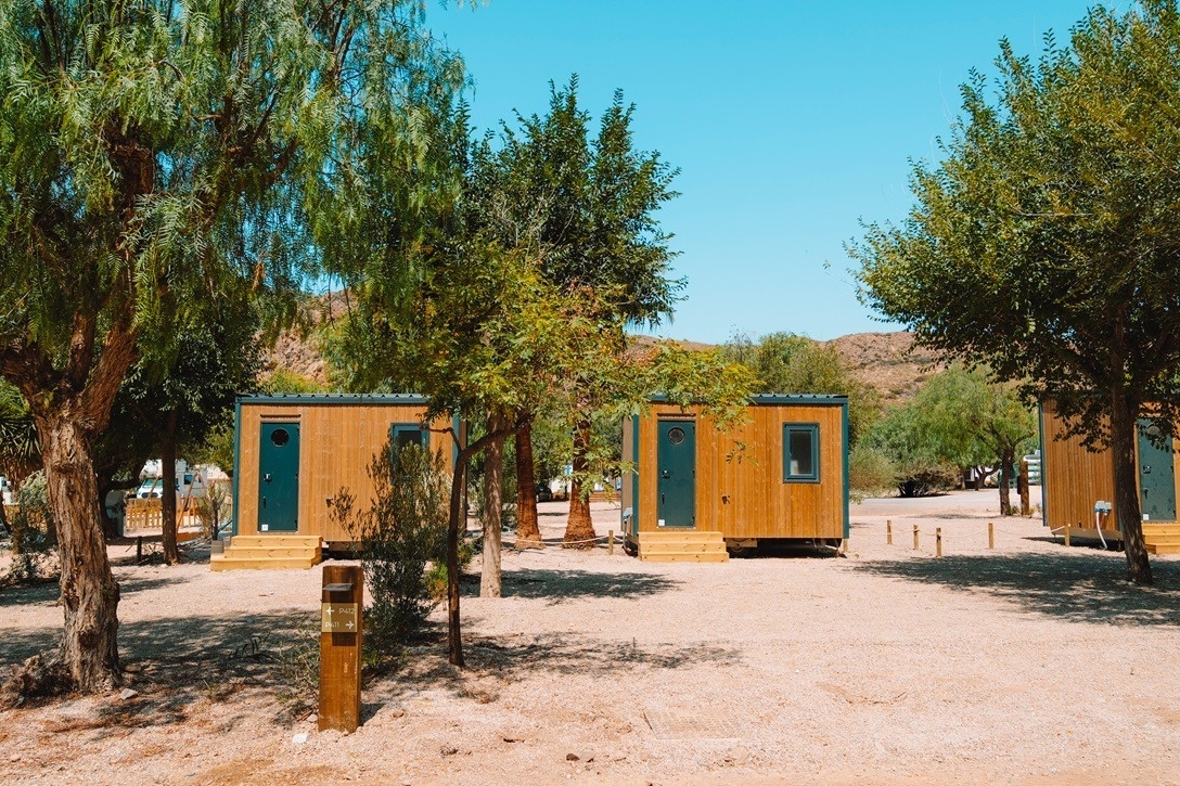 tres pequeñas cabañas de madera están alineadas una al lado de la otra
