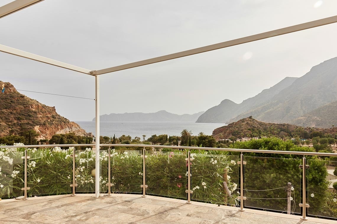 a balcony with a view of the ocean and mountains