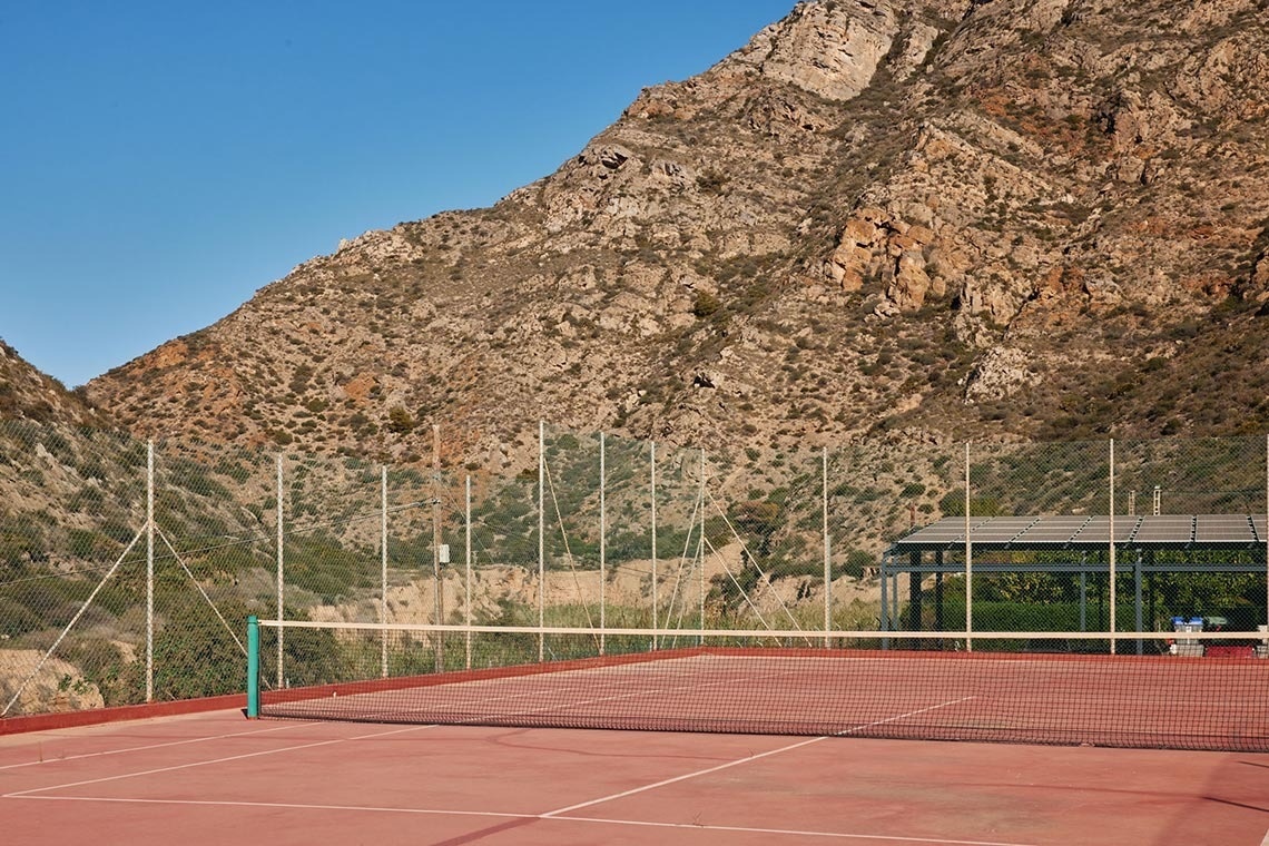 a tennis court with a mountain in the background