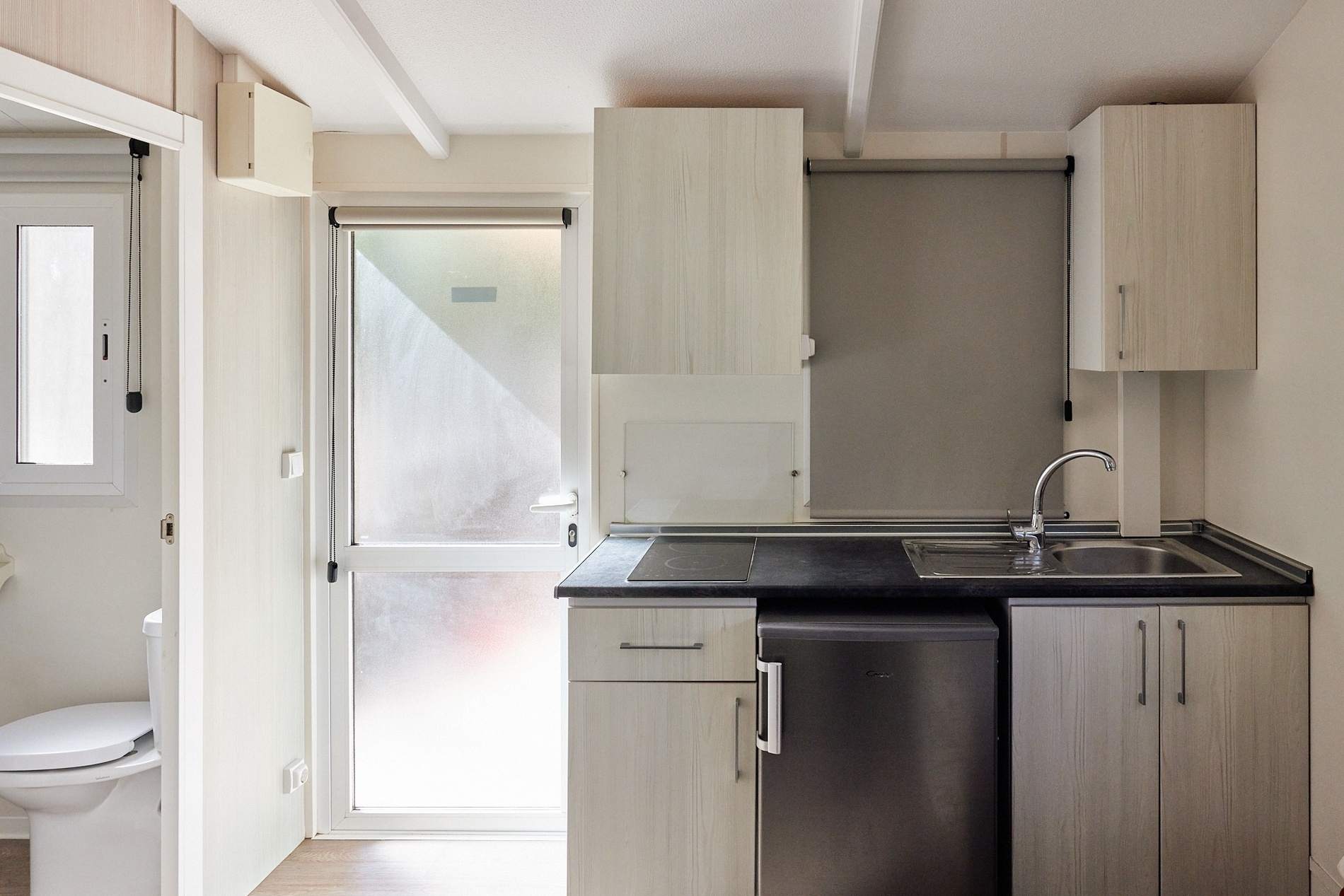 a kitchen with white cabinets and a stainless steel refrigerator