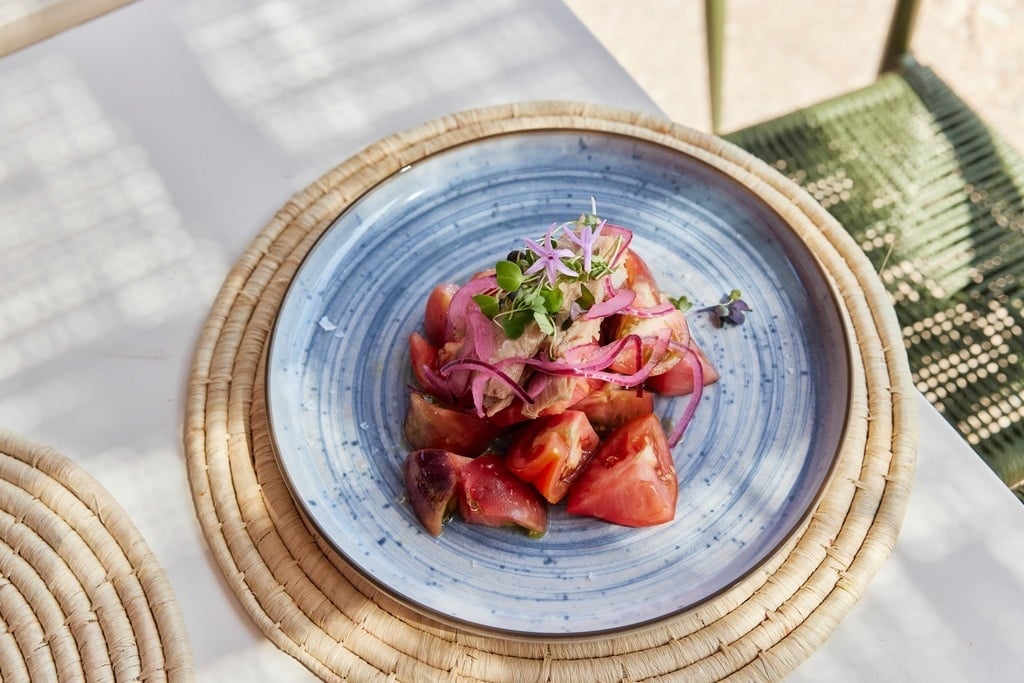 a group of people sit at tables outside a building with a sign that says bar