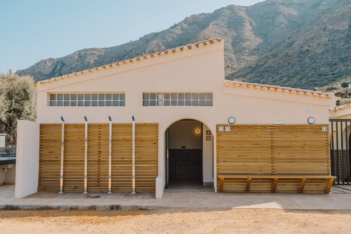 un edificio blanco con una pared de madera y una puerta