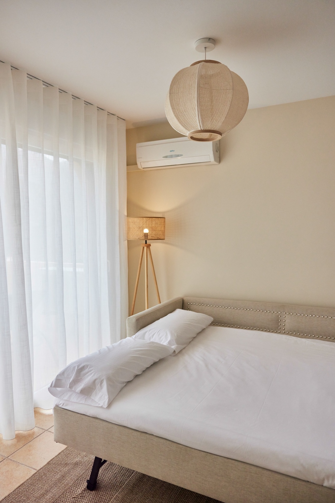 a bedroom with a couch and a lamp