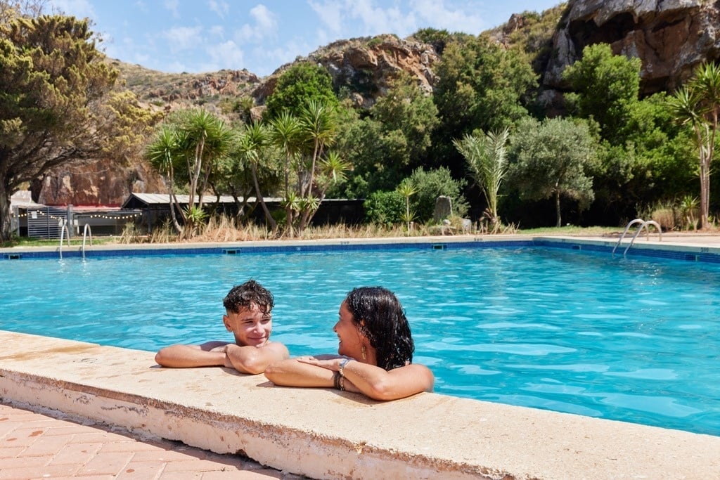 ein Mann schwimmt auf einem Surfbrett im Pool