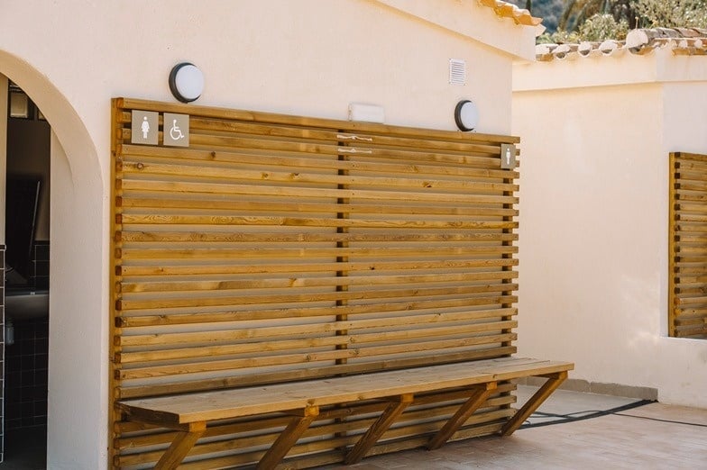 ein Badezimmer mit vielen Waschbecken und einem Schild an der Wand