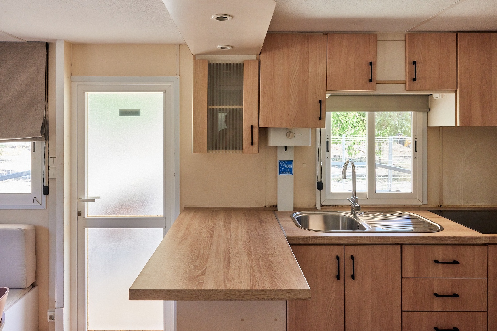 a kitchen with wooden cabinets and a stainless steel sink