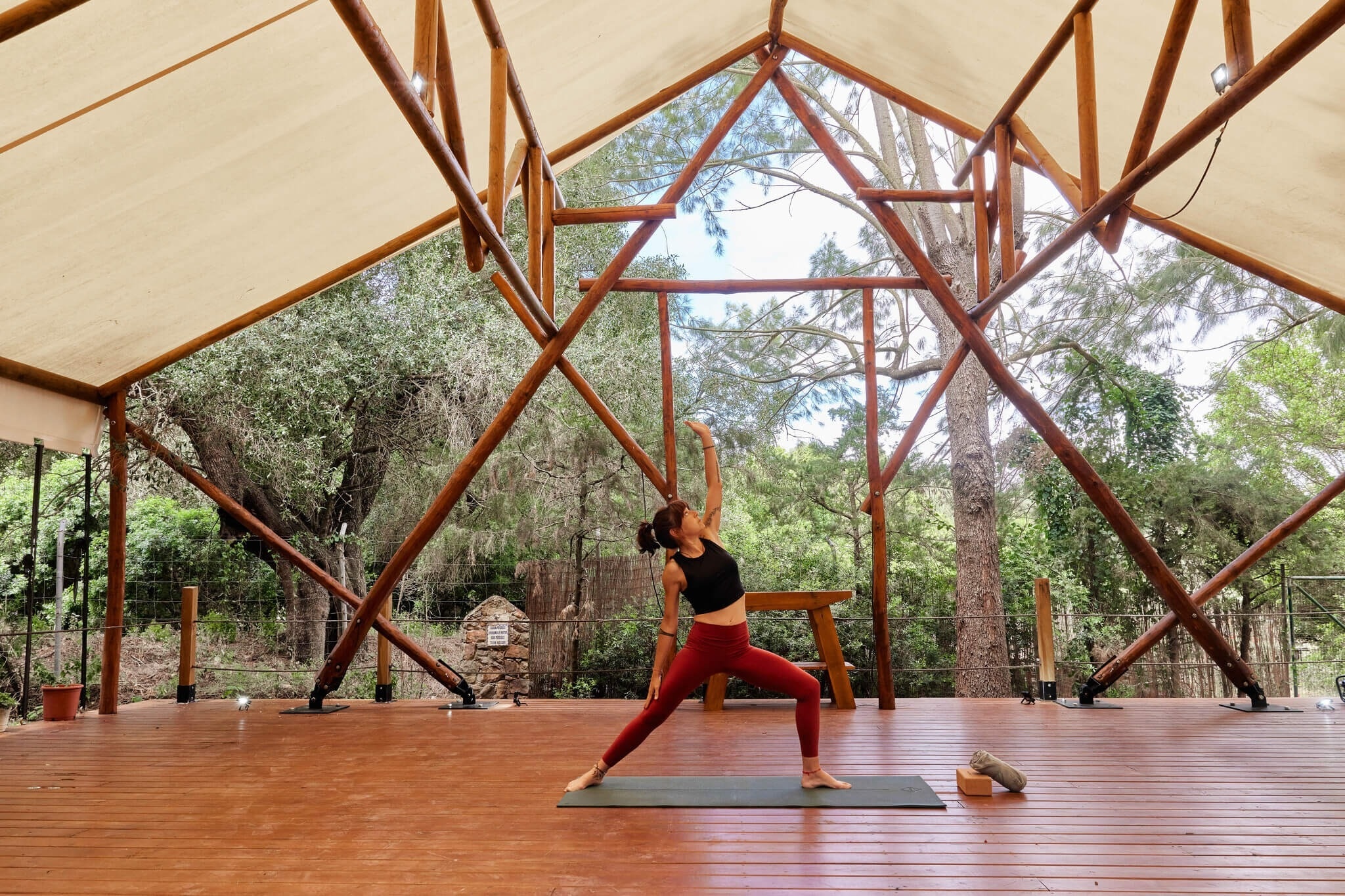 una jove està practicant yoga en una tenda de bambú
