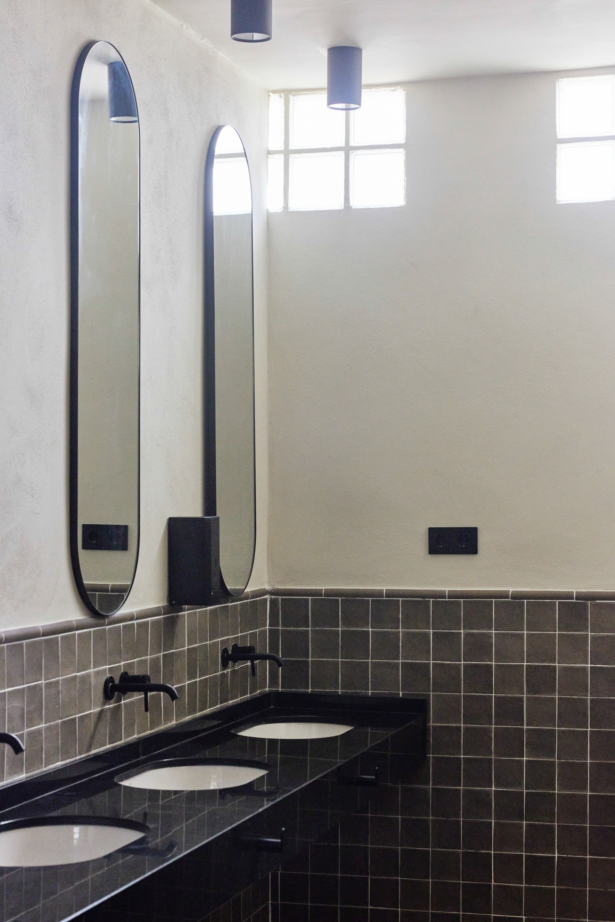 un baño con dos lavabos y dos espejos