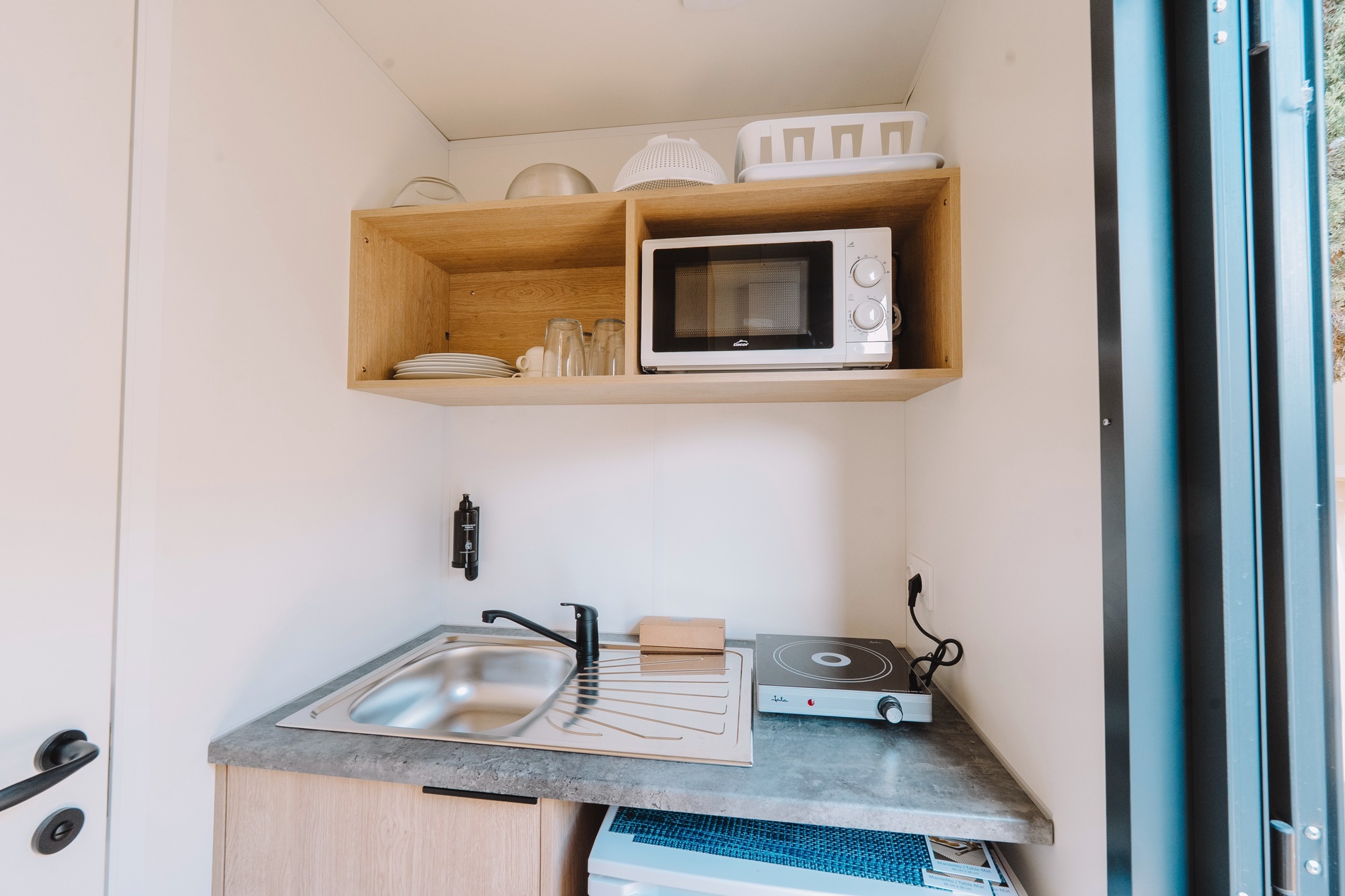 eine kleine Küche mit einem Spülbecken und einem Mikrowellenherd