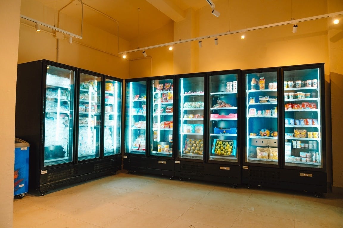 eine Frau hält einen blauen Wäschekorb voller Wäsche