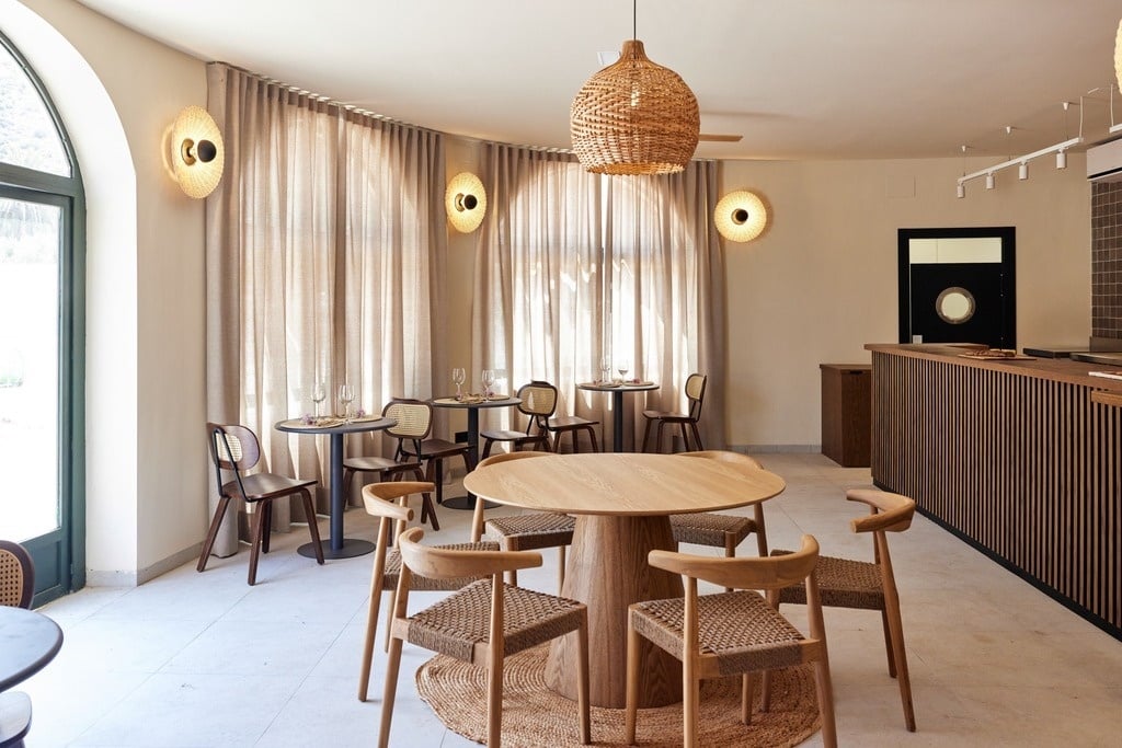 a group of people sit at tables outside a building with a sign that says bar