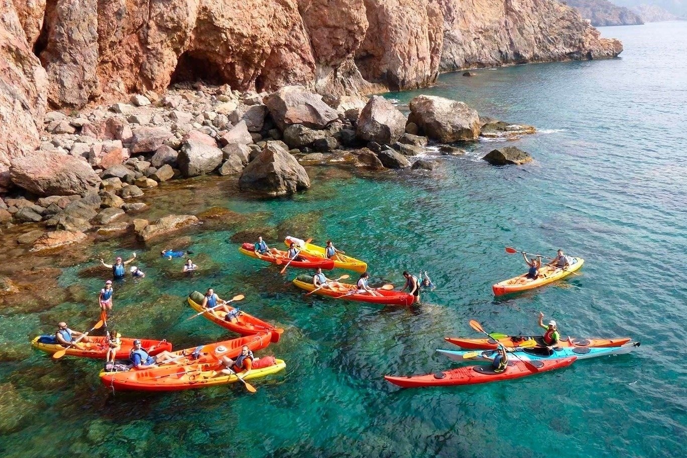 a group of people in red and yellow kayaks in the water