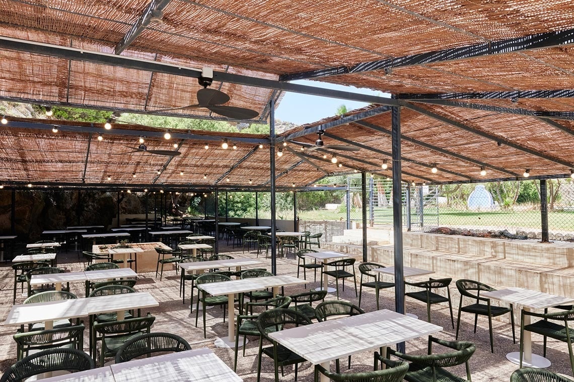 a restaurant with tables and chairs under a canopy