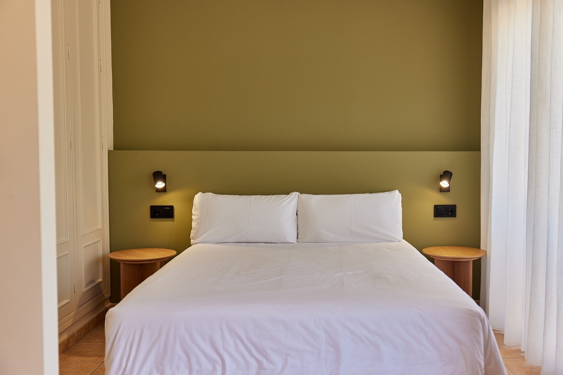 una habitación con una cama y dos mesitas de noche