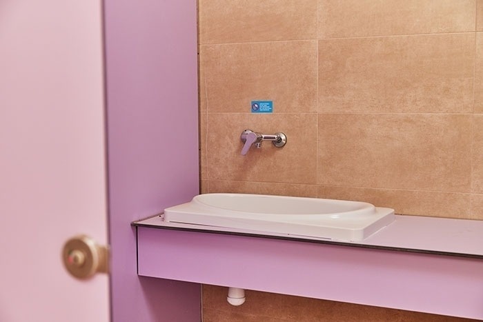 a bathroom with a purple door and a white sink