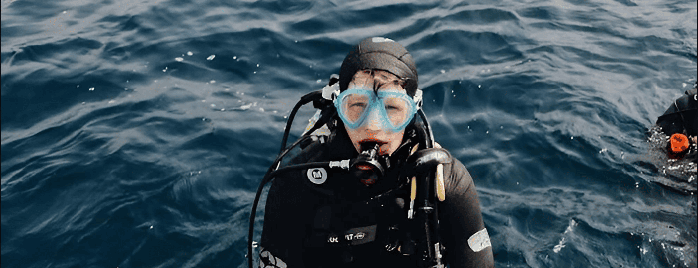 un buzo con una máscara de buceo y un chaleco de neopreno con la letra t en el pecho