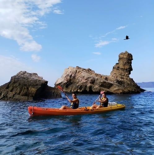 two people walking down a path in the mountains