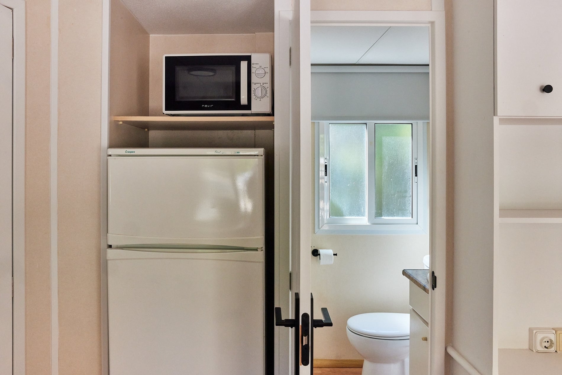 a white refrigerator with a microwave above it